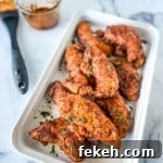 Fresh Chicken Recipes for Summer Grilling and Light Meals 15 a white serving platter with Nashville Chicken Tenders with a basting brush and spicy hot butter sauce in the background.
