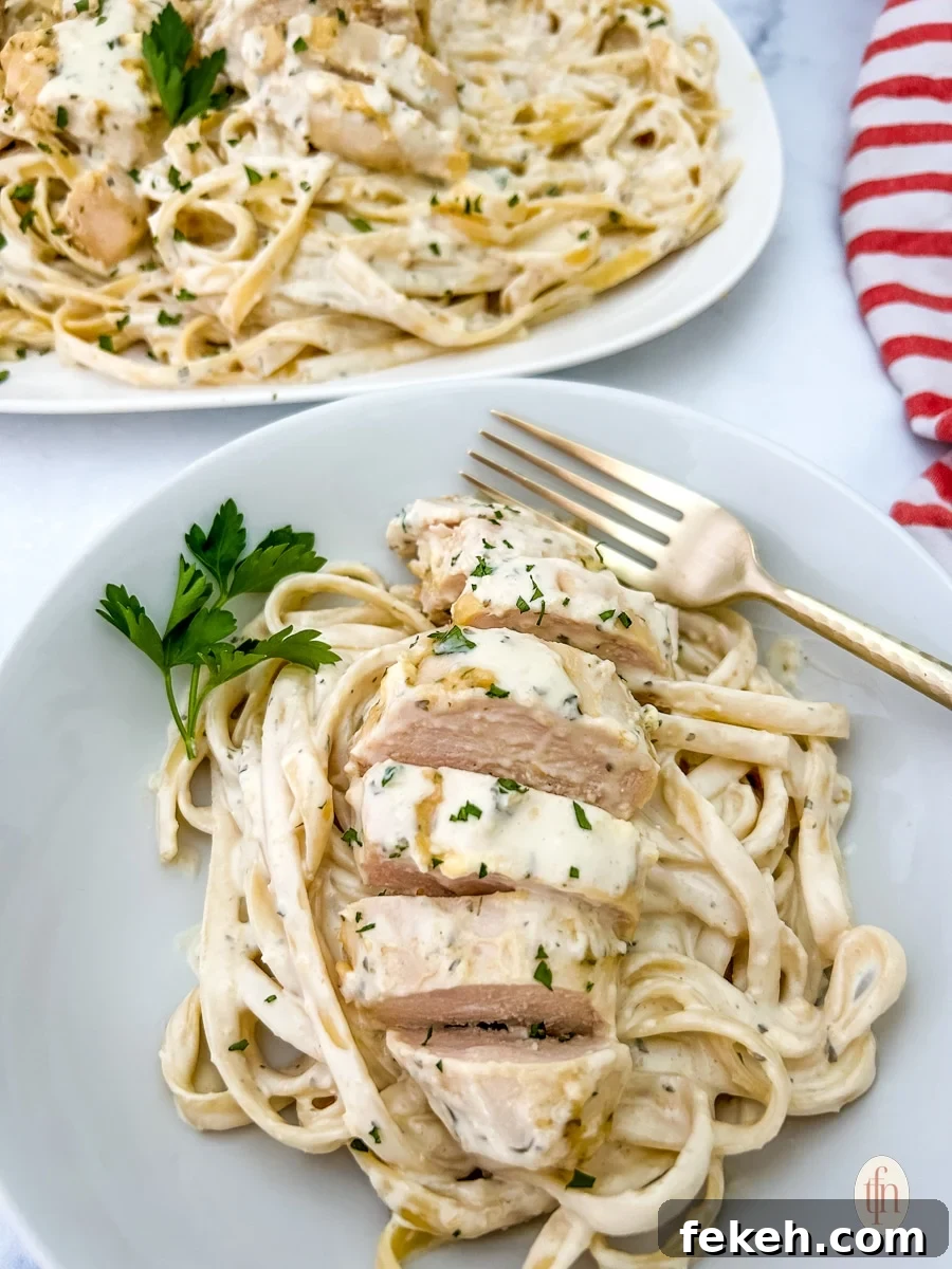 Fresh Chicken Recipes for Summer Grilling and Light Meals 4 Garlic parmesan chicken pasta on a white bowl with fork.