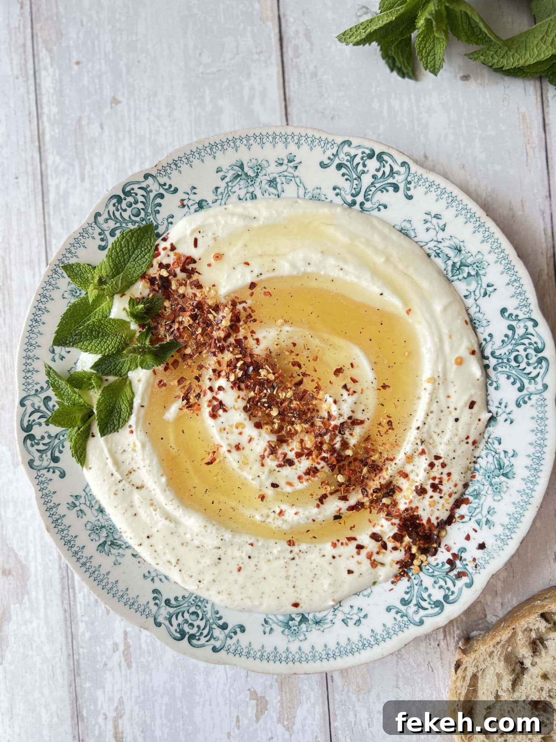 Homemade Hot Honey Recipe: Spicy Sweet Sauce for Pizza & More 5 whipped ricotta cheese on a blue plate with honey and chilli flakes.