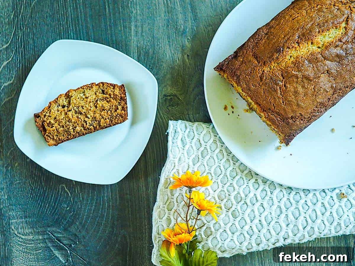 Banana Bread Made in a Bread Machine: Simple Step-by-Step Recipe 2 A loaf of bread machine banana bread on a white plate with a slice on a smaller white plate.