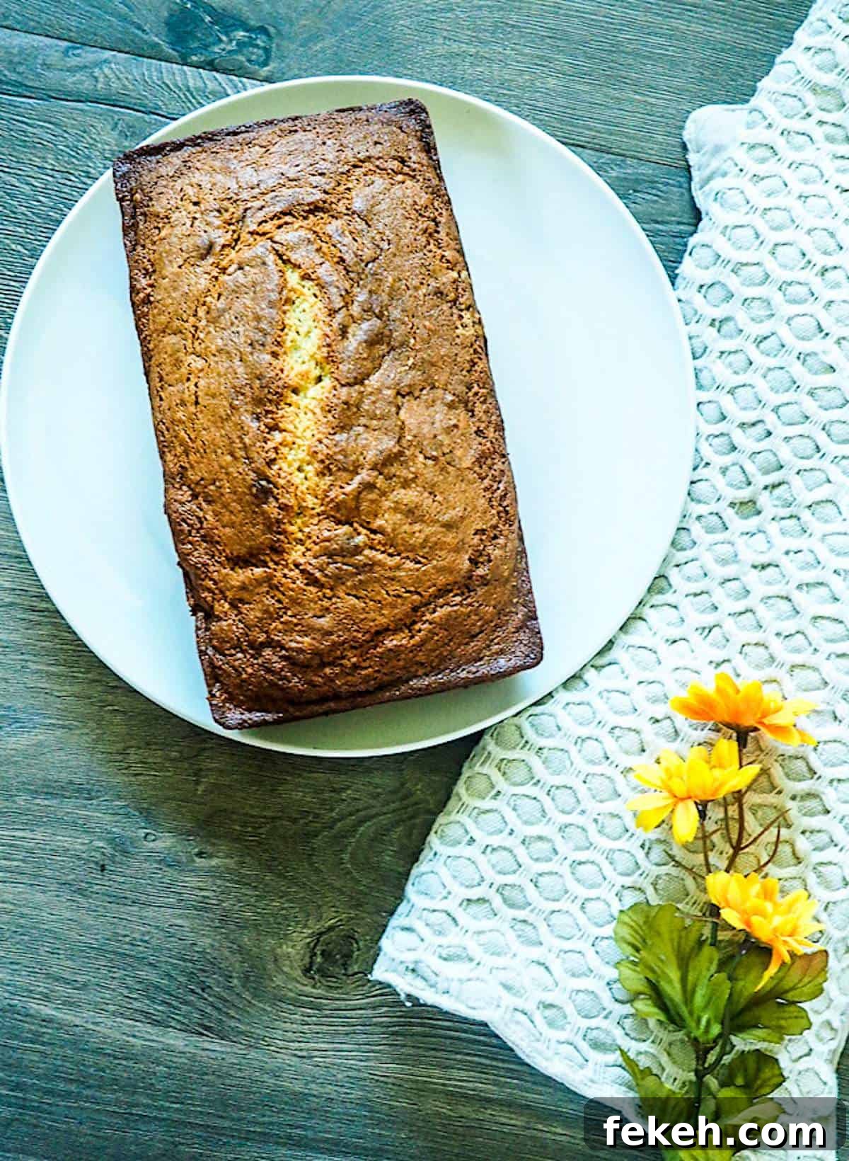 Banana Bread Made in a Bread Machine: Simple Step-by-Step Recipe 4 A loaf of bread machine banana bread on a white plate.