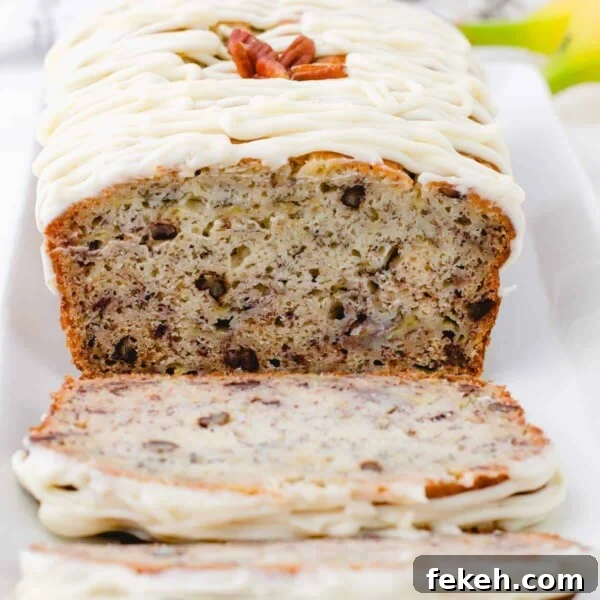Banana Bread Made in a Bread Machine: Simple Step-by-Step Recipe 7 A cross section of a loaf of buttermilk banana bread with cream cheese frosting drizzled on the top.