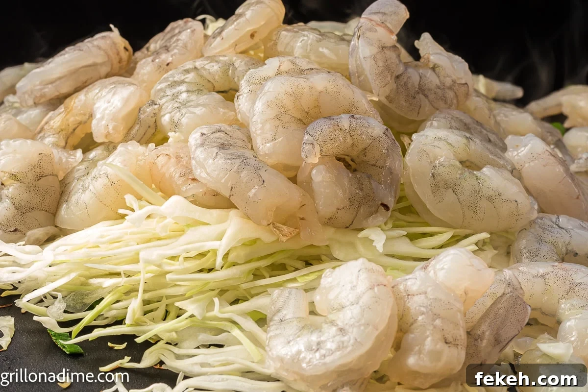 Blackstone Shrimp Yakisoba Recipe — Quick Griddle Noodle Stir-Fry 5 Shredded cabbage and uncooked shrimp on the griddle
