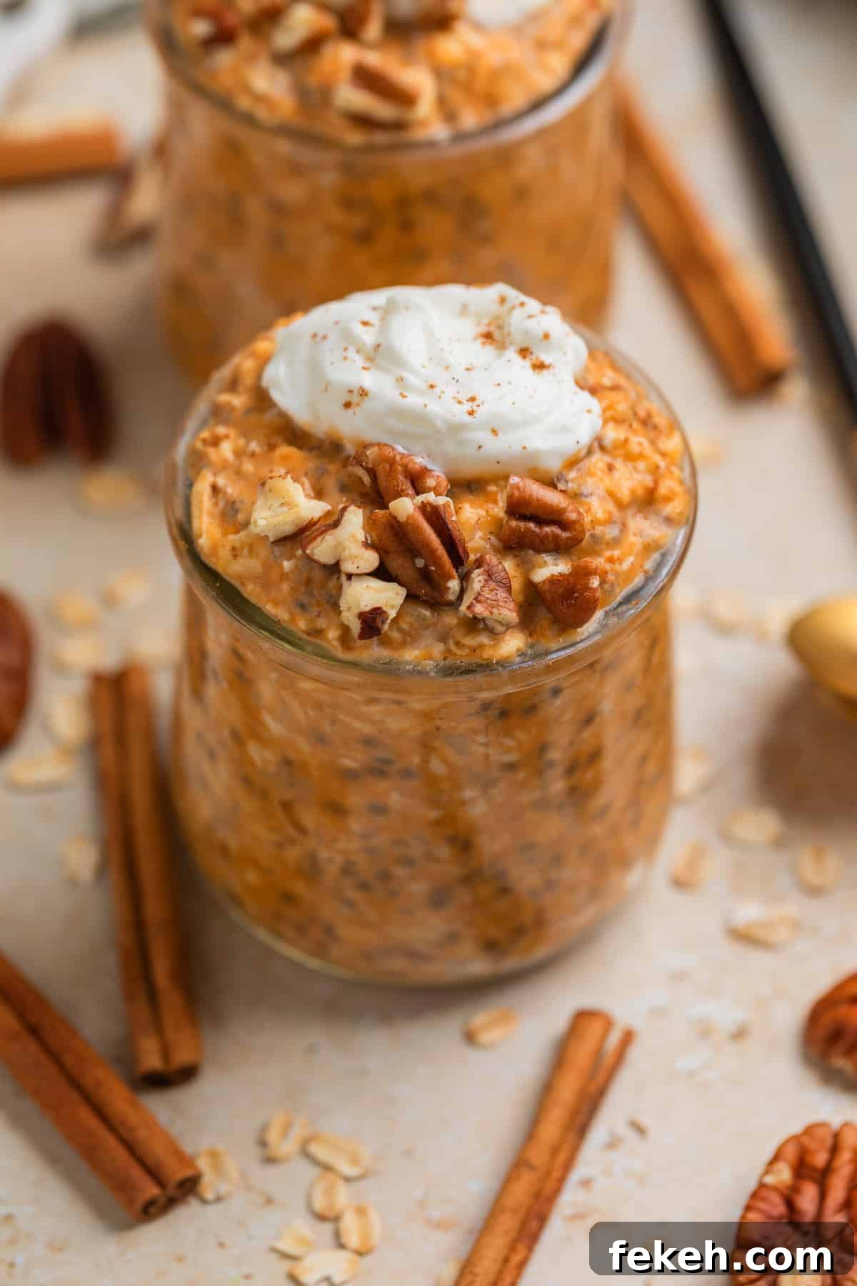 Pumpkin Pie Overnight Oats Recipe for Quick Fall Breakfast 2 Glass jar with pumpkin pie overnight oats topped with whipped cream and chopped pecans.