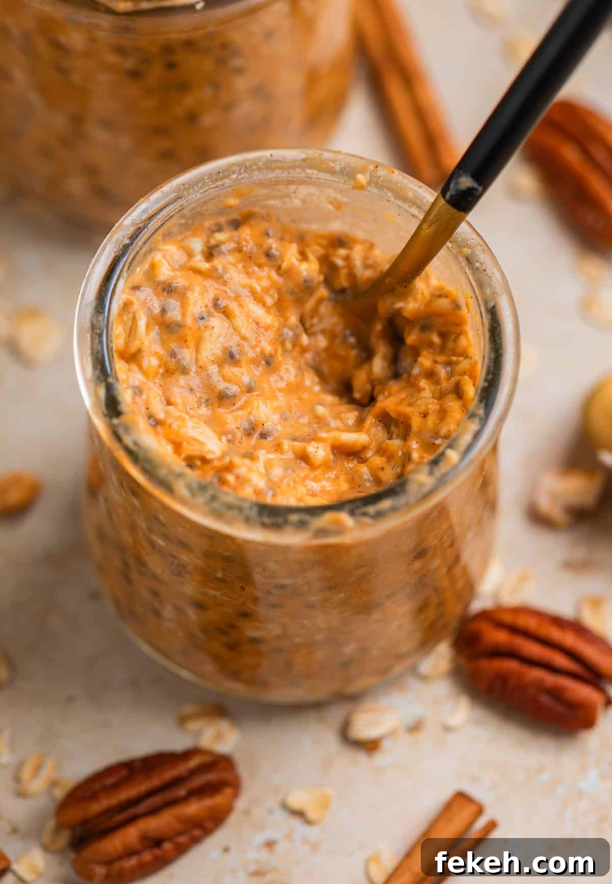 Pumpkin Pie Overnight Oats Recipe for Quick Fall Breakfast 4 Jar with spoon scooping into pumpkin oatmeal.