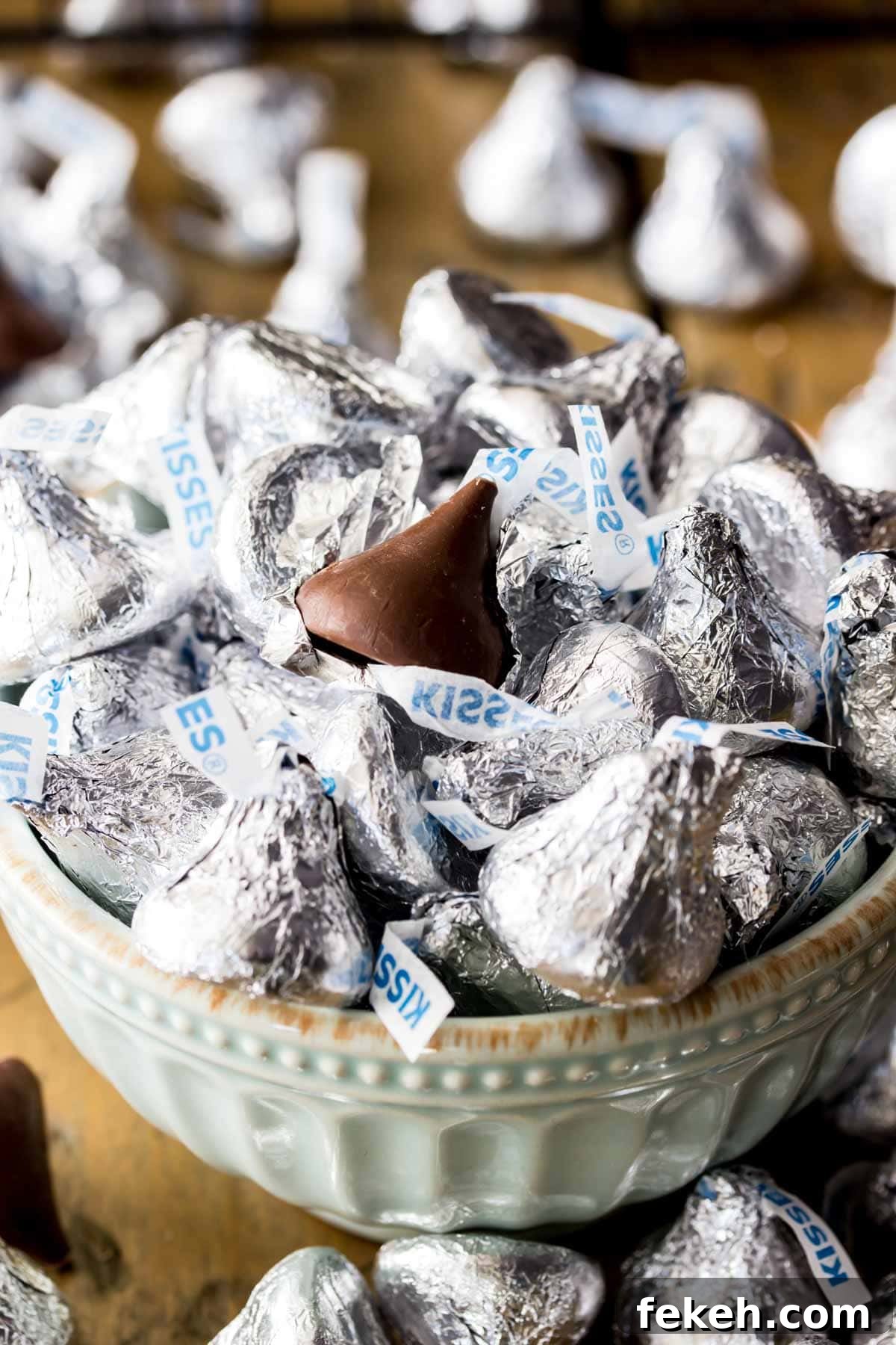 Bowl of Hershey kisses, with the top kiss missing its wrapper.