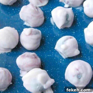 Yogurt covered blueberries on a blue surface
