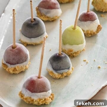 yogurt dipped frozen grapes in 2 lines on a white plate