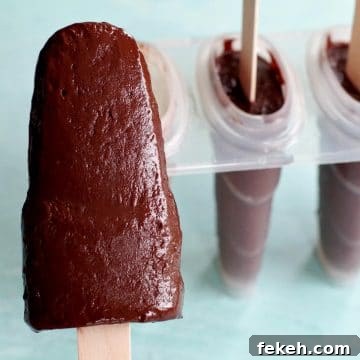 banana fudge popsicle with popsicle mold in the background