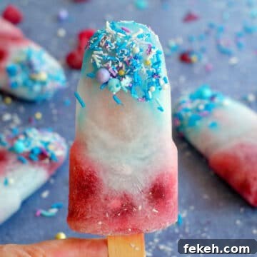 blue raspberry popsicle being held up with more in the background