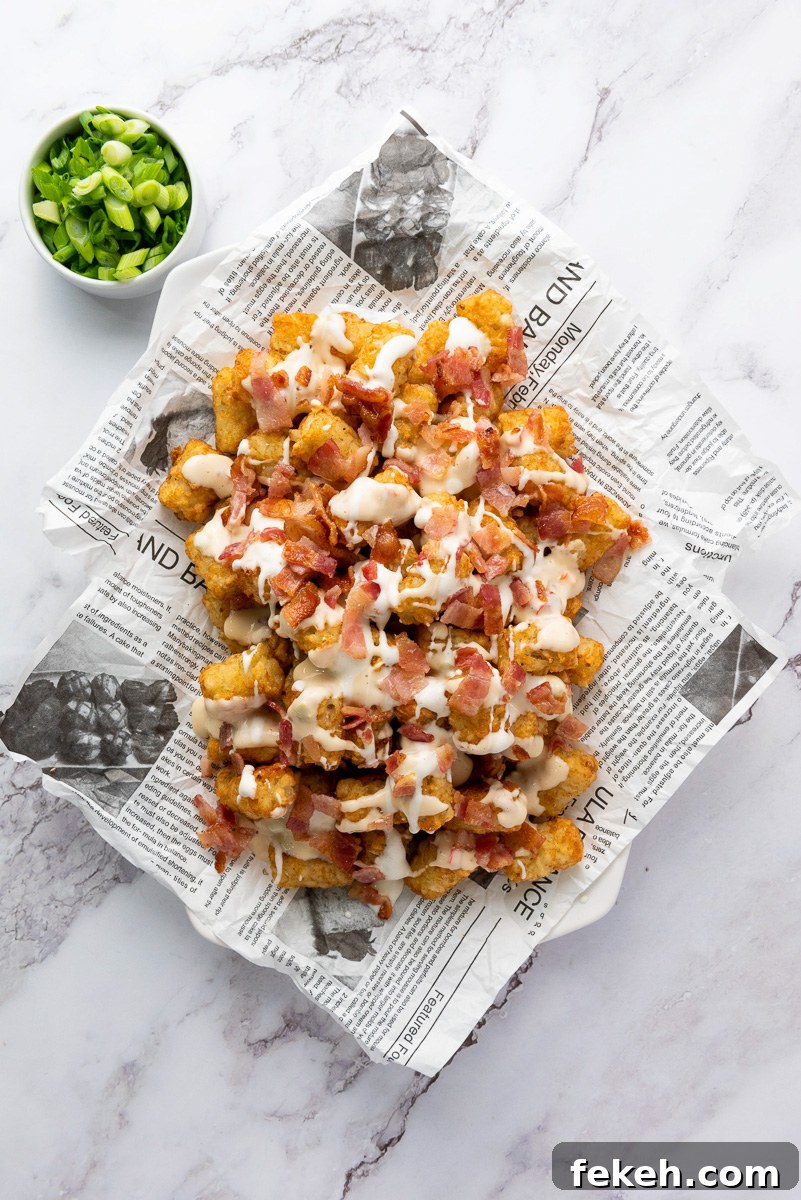Cheesy Bacon Loaded Tater Tot Nachos (Totchos) 7 Ranch dressing is drizzled on top.