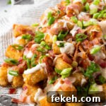 Loaded tater tots on a plate.