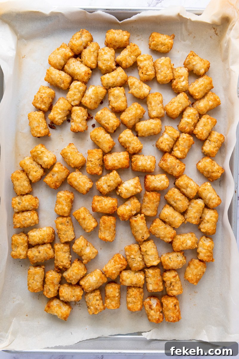 Cheesy Bacon Loaded Tater Tot Nachos (Totchos) 6 Cooked tater tots on baking sheet.