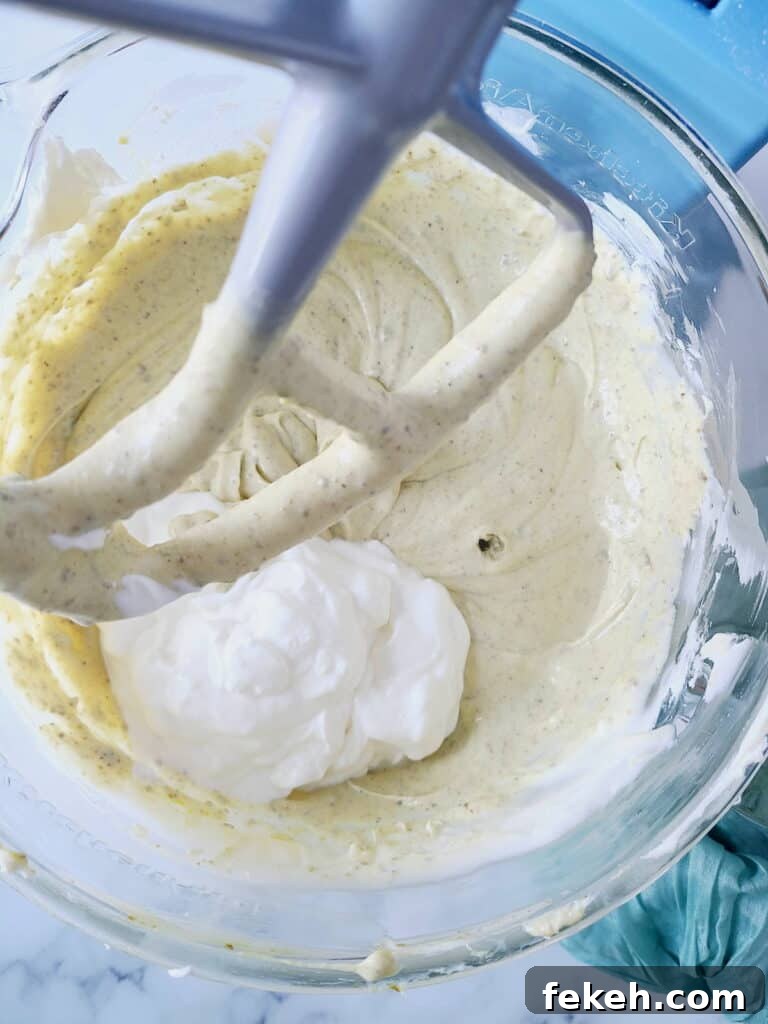 Creamy Pistachio Cheesecake with Real Pistachios and Homemade Paste 12 Adding sour cream into cheesecake batter