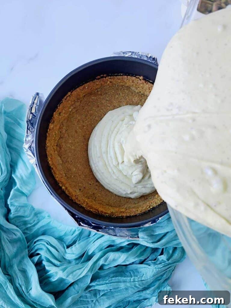 Creamy Pistachio Cheesecake with Real Pistachios and Homemade Paste 14 Pouring cheesecake batter into a pan