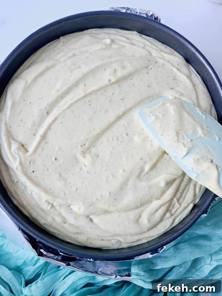 Creamy Pistachio Cheesecake with Real Pistachios and Homemade Paste 15 Smoothing cheesecake batter with spatula