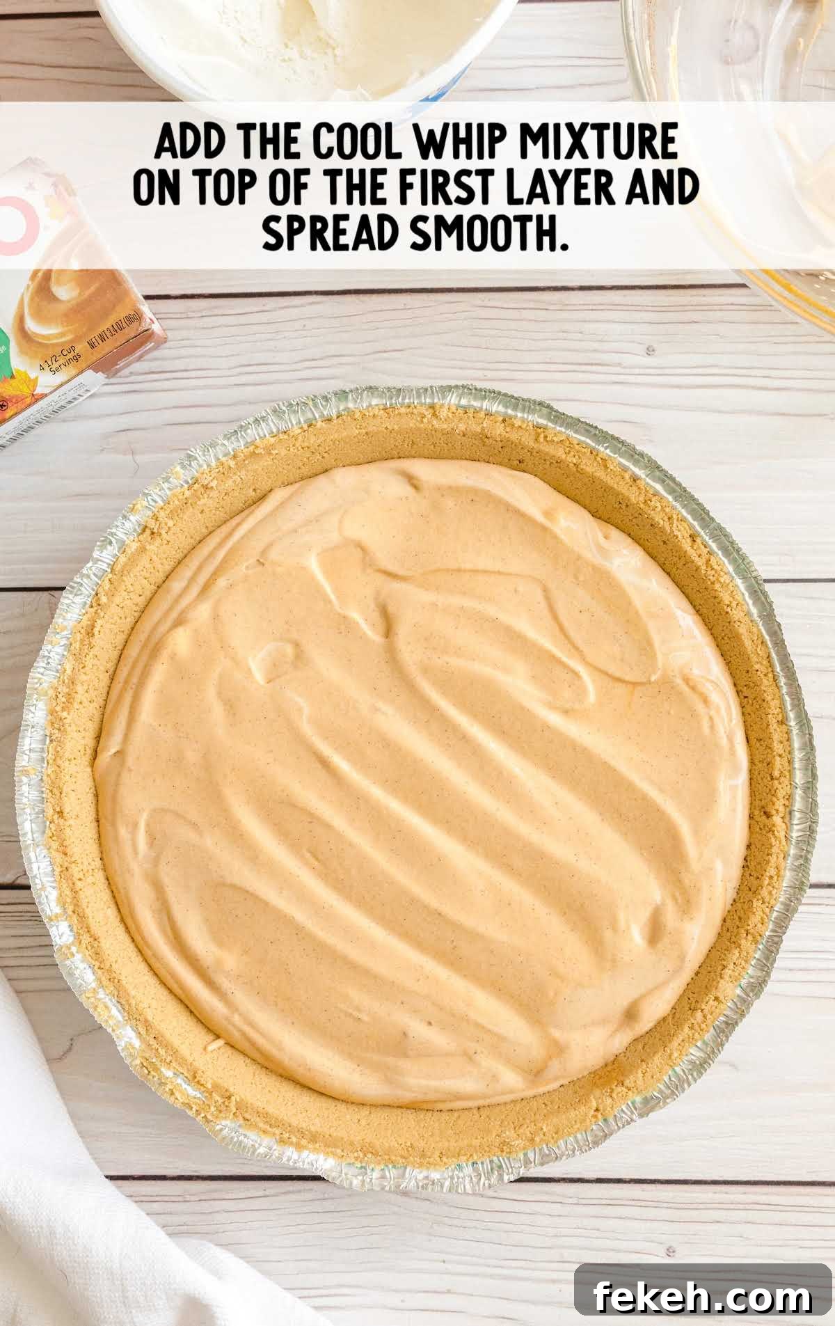 No-Bake Pumpkin Pie with Jello Filling 5 Final whipped topping layer being spread over the chilled pumpkin spice Jello pie.