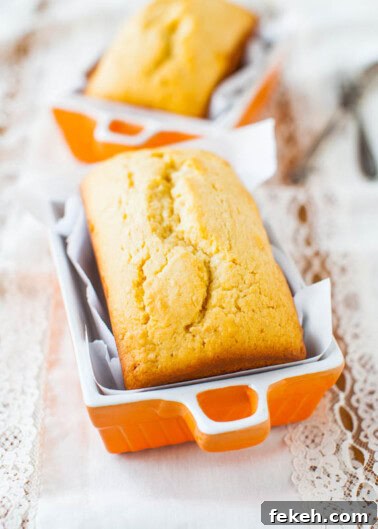 Classic Cream Cheese Pound Cake Recipe for Moist, Tender Slices 24 Freshly baked loaf cake in an orange ceramic baking dish.