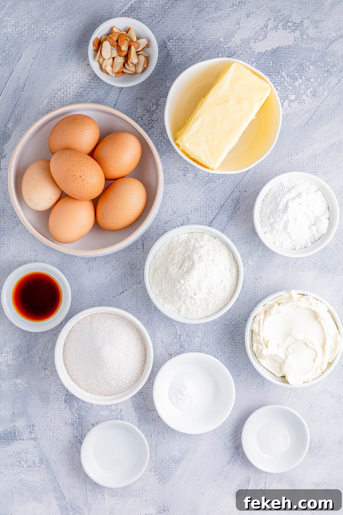 Classic Cream Cheese Pound Cake Recipe for Moist, Tender Slices 5 Ingredients for baking including eggs, butter, flour, sugar, vanilla extract, baking powder, baking soda, sour cream, and sliced almonds arranged on a textured surface.