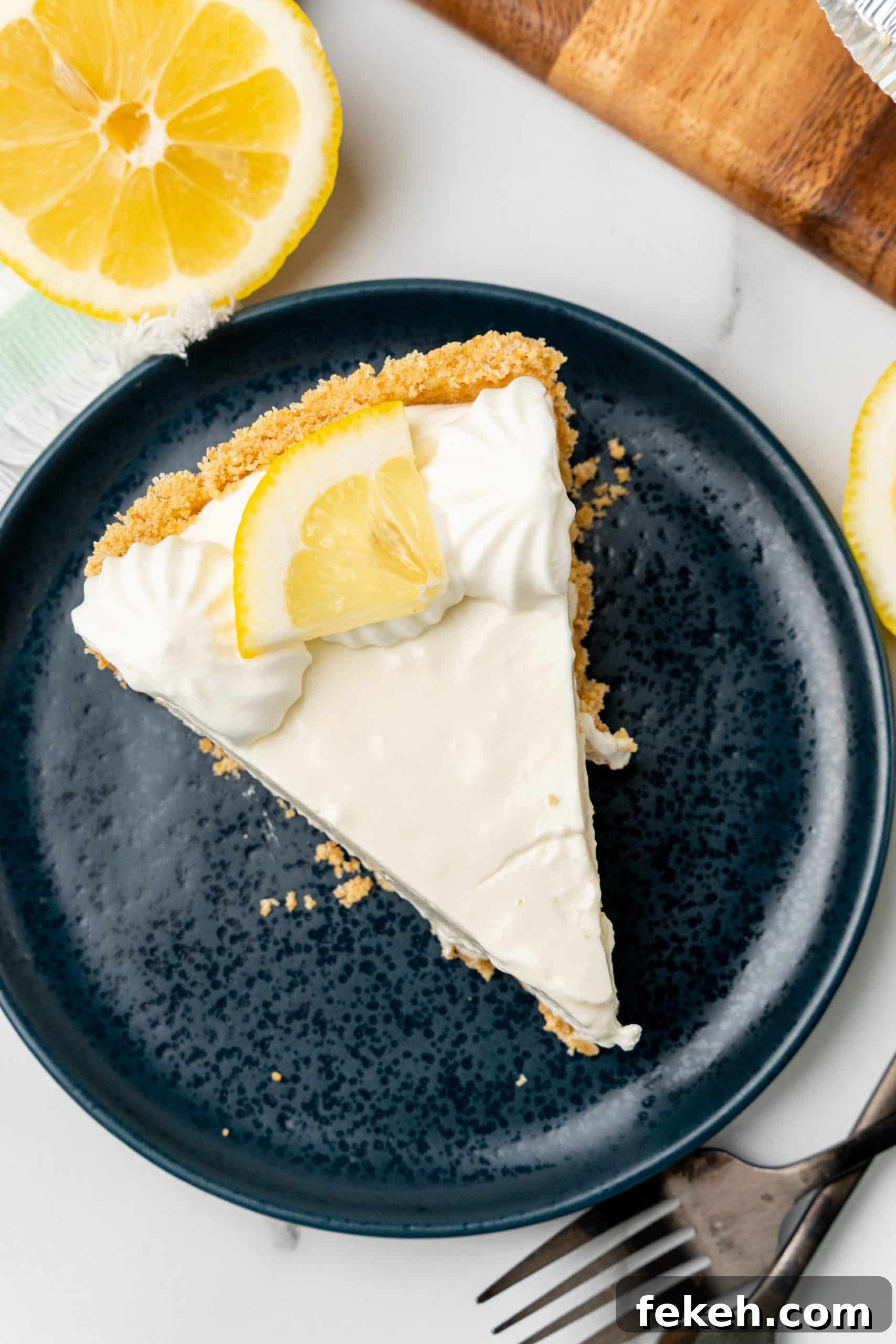 No-Bake Lemonade Cream Pie Recipe: Refreshing Summer Dessert 13 a slice of no bake lemonade cheesecake on a small blue plate
