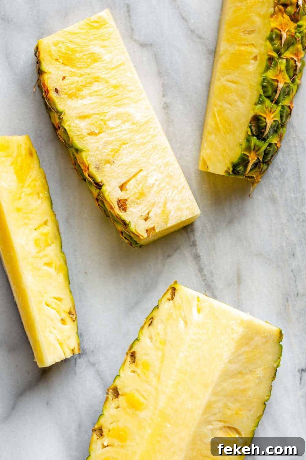 How to Make Stoli Doli: Puerto Rican Coconut Rum Dessert Recipe 4 Slices of pineapple on a marble surface