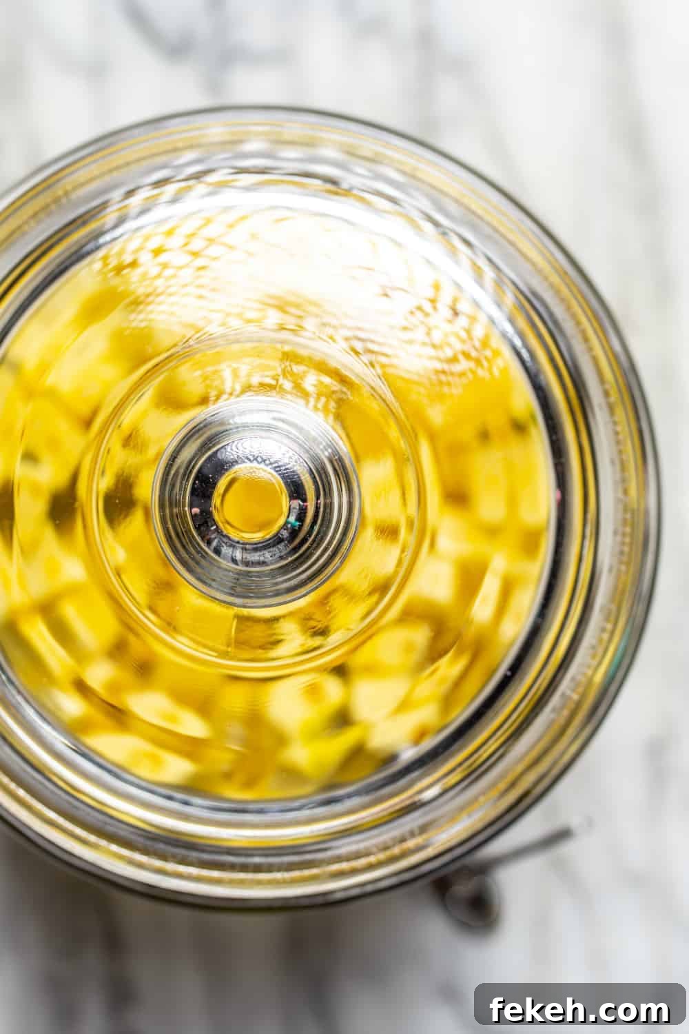 How to Make Stoli Doli: Puerto Rican Coconut Rum Dessert Recipe 7 Glass container filled with diced pineapple and vodka