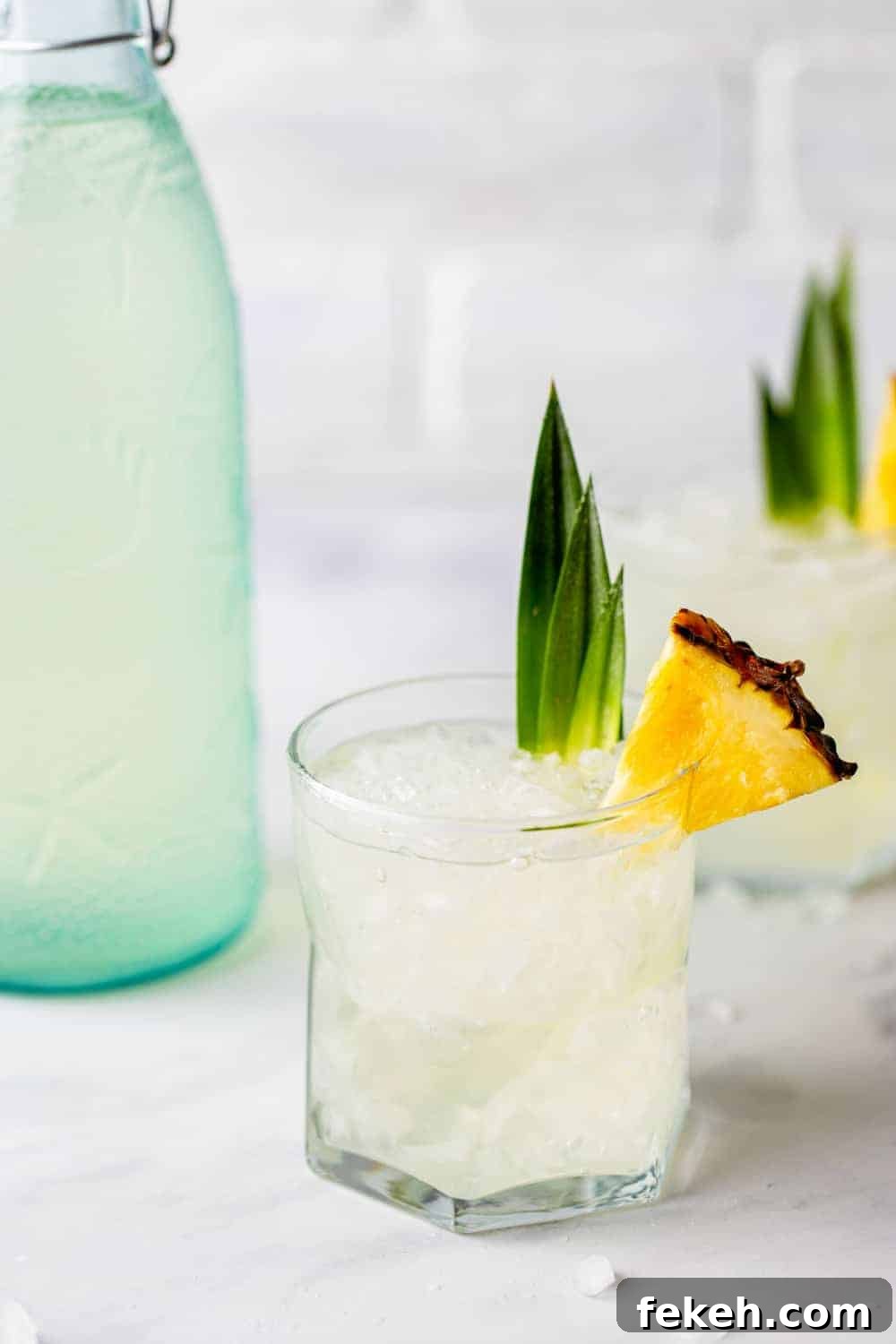 How to Make Stoli Doli: Puerto Rican Coconut Rum Dessert Recipe 10 Stoli Doli in a rocks glass next to a bottle of pineapple vodka