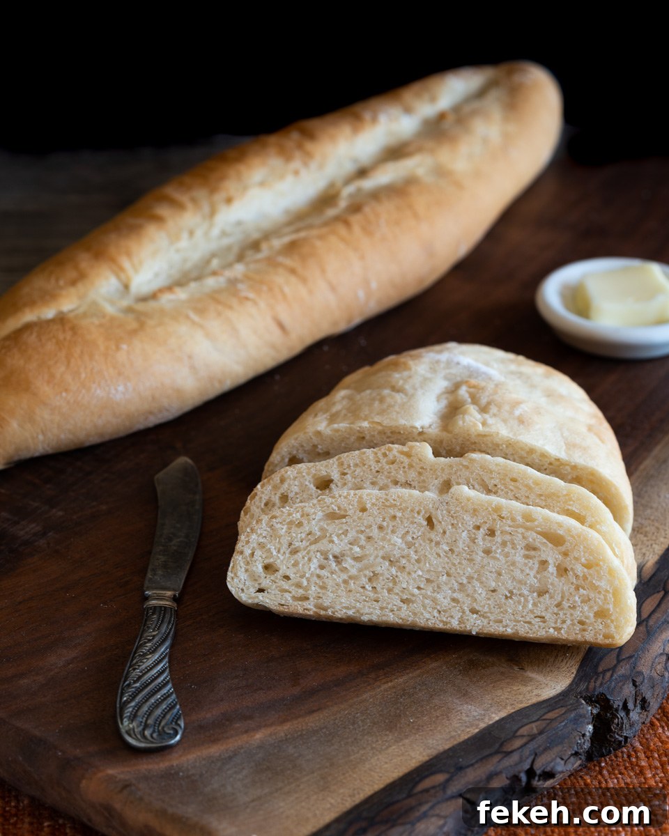 Authentic Cuban Bread (Pan Cubano) Recipe for Crispy Loaf 13 A loaf of sliced bread sitting in front of an uncut loaf of homemade bread - Hostess At Heart