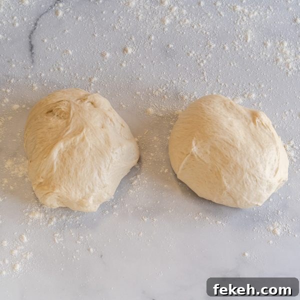 Authentic Cuban Bread (Pan Cubano) Recipe for Crispy Loaf 8 Bread dough split in half on a floured surface - Hostess At Heart