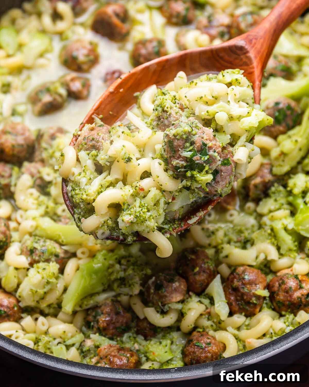 Macaroni and Broccoli with Mini Meatballs Recipe 7 Large wooden spoon holding macaroni with broccoli and meatballs.
