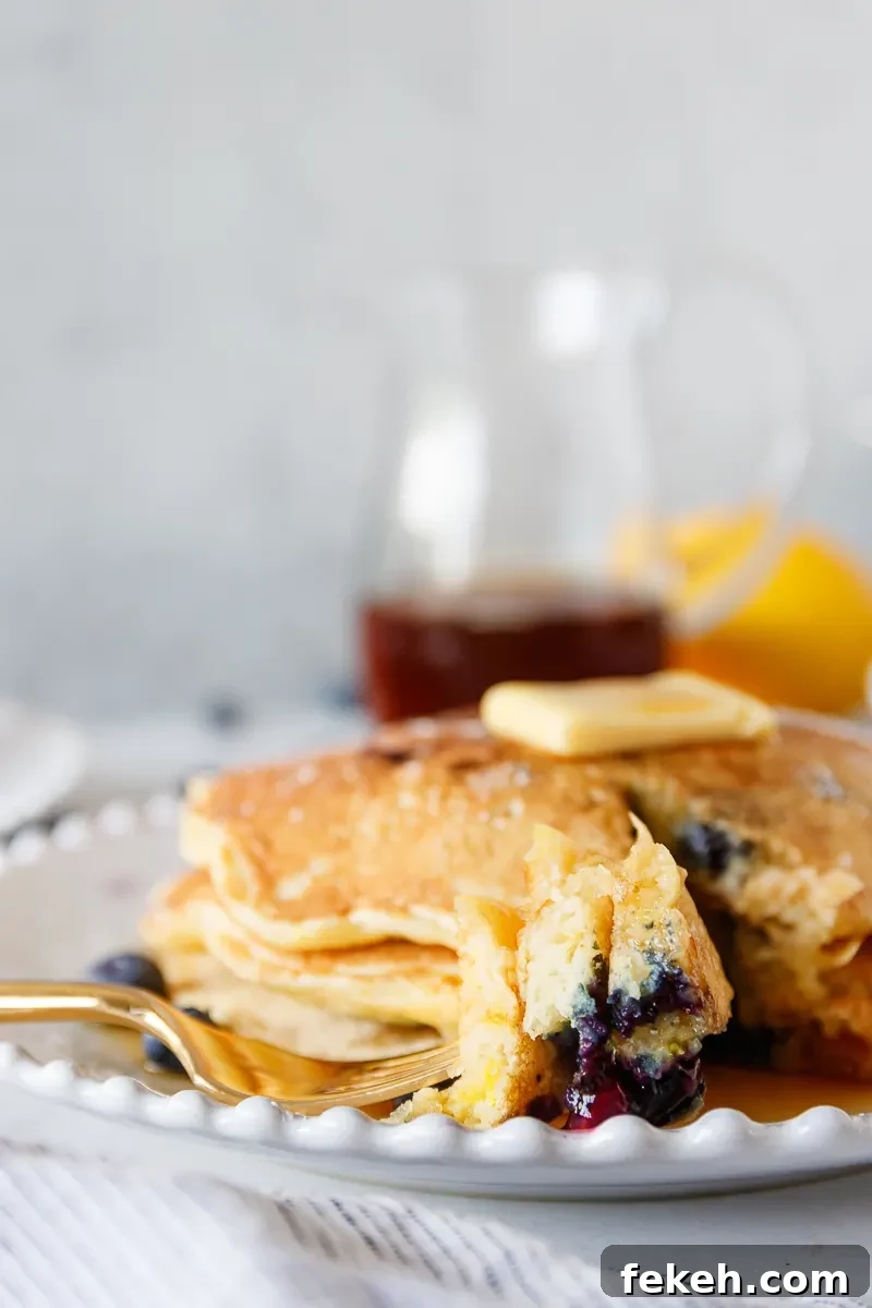 Lemon Blueberry Pancakes Recipe with Fluffy Buttermilk Stack 8 cut piece of the pancake stack on a fork to show the texture