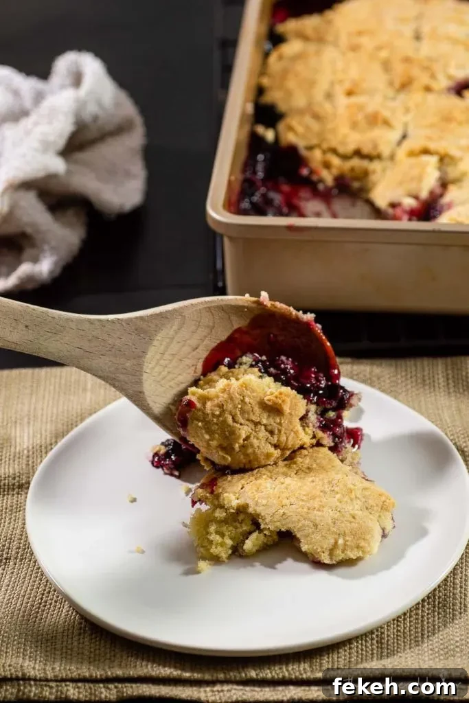 Summery Mixed Berry Cobbler Recipe with Crisp Oat Topping 3 Mixed berry cobbler being spooned onto a plate