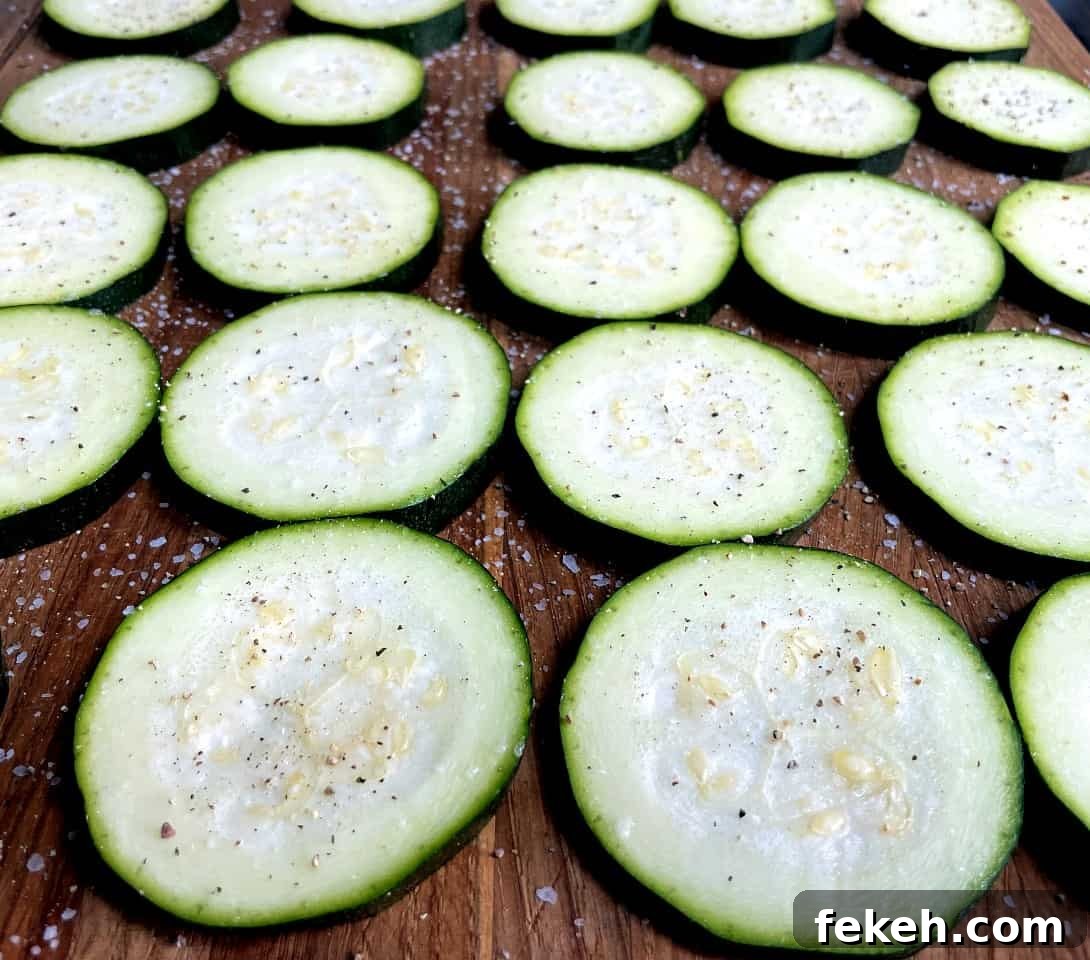Air Fryer Zucchini Pizza Bites Recipe for Crispy, Low-Carb Snacks 4 sliced zucchini with salt and pepper on top.