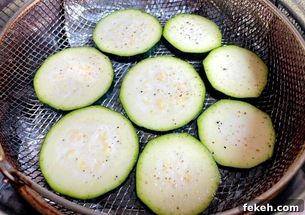 Air Fryer Zucchini Pizza Bites Recipe for Crispy, Low-Carb Snacks 5 sliced zucchini in an air fryer.