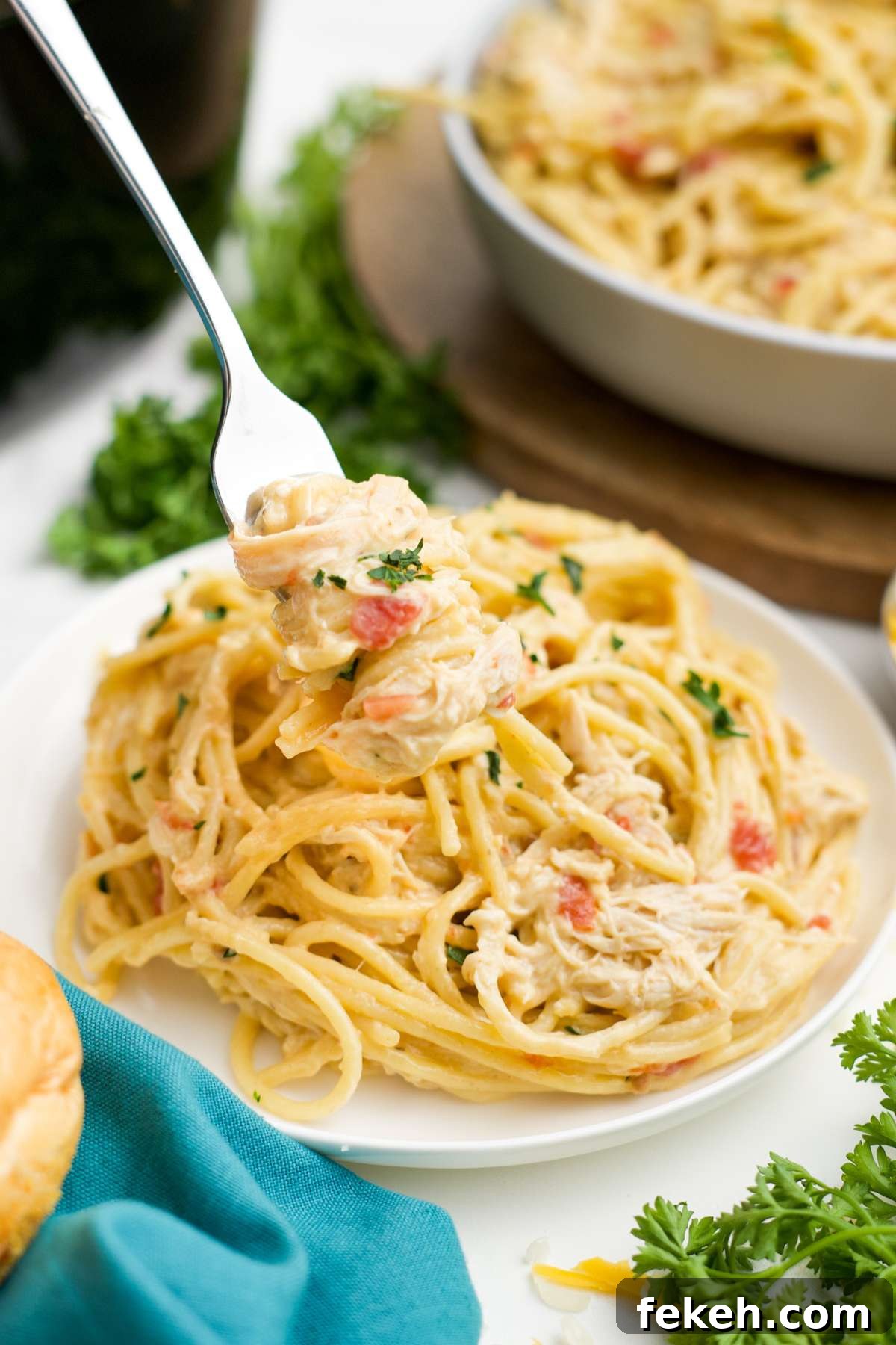 A plate of slow cooker chicken spaghetti with a fork twirling some up.