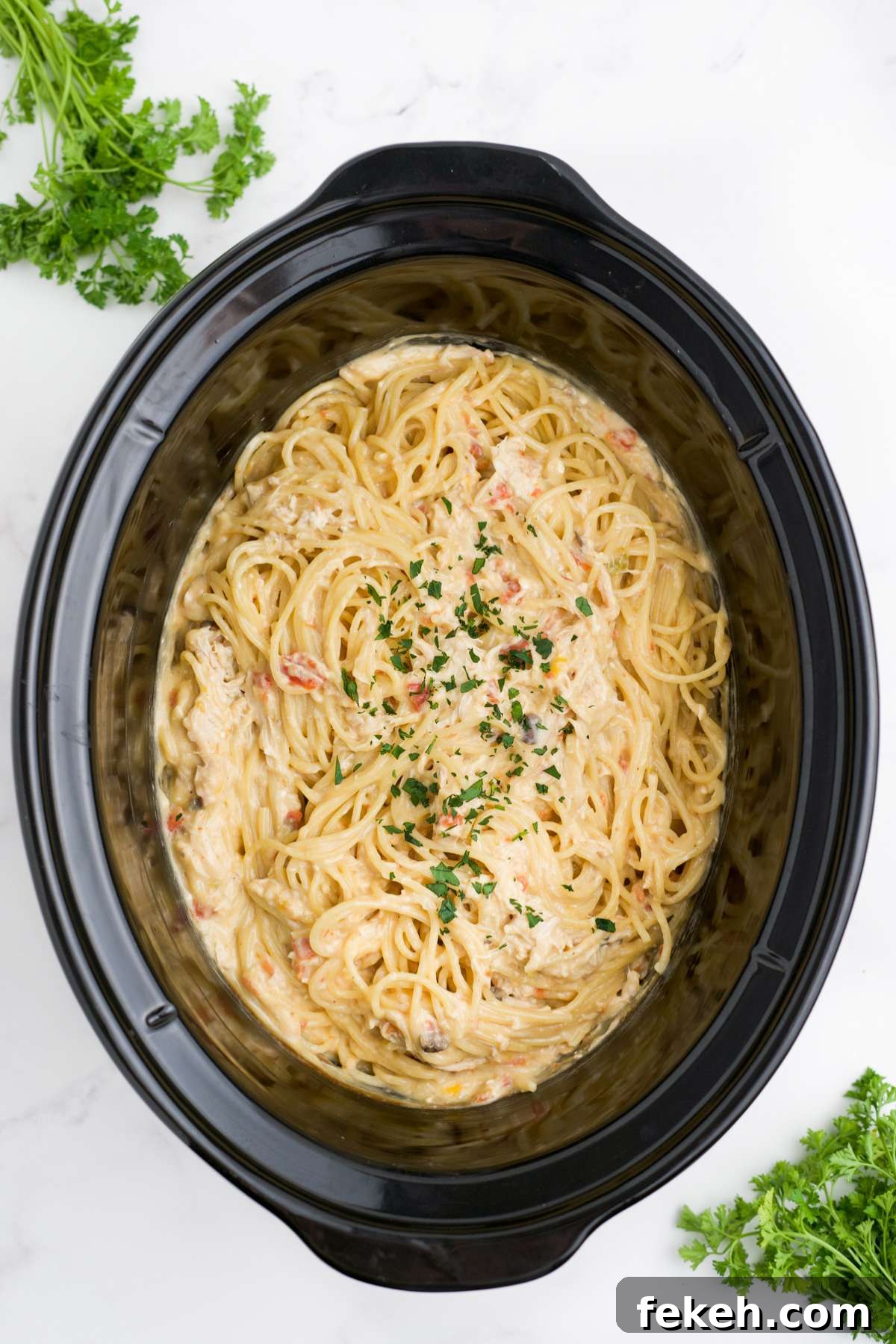 Pasta added and the chicken spaghetti in the slow cooker is ready to serve.