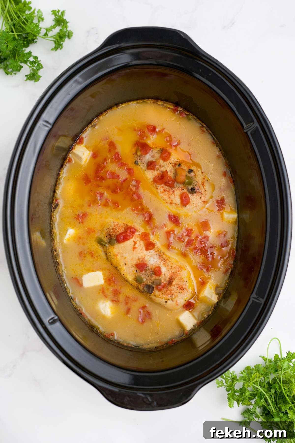 Chicken cooked in the sauce in a slow cooker.