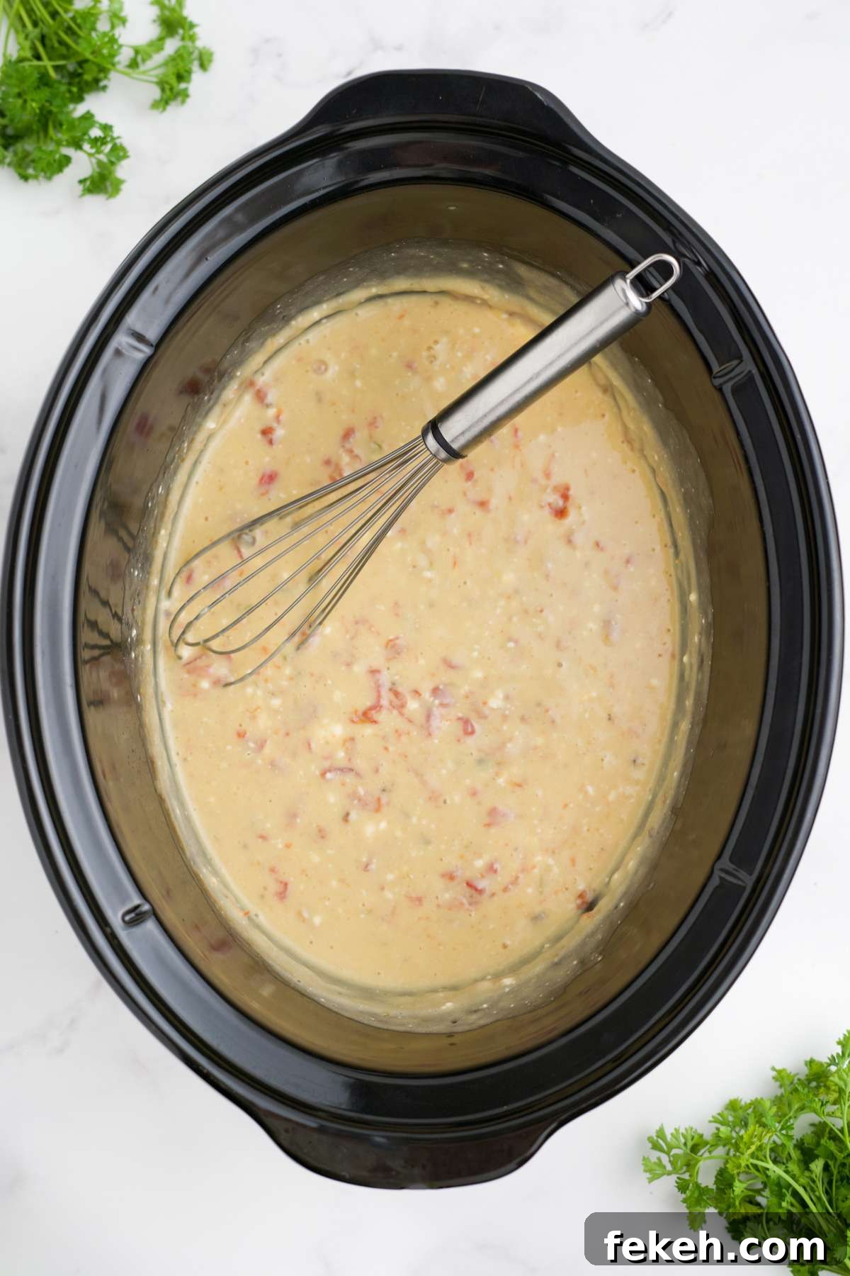 The chicken has been removed from the crockpot and the sauce whisked together until creamy.