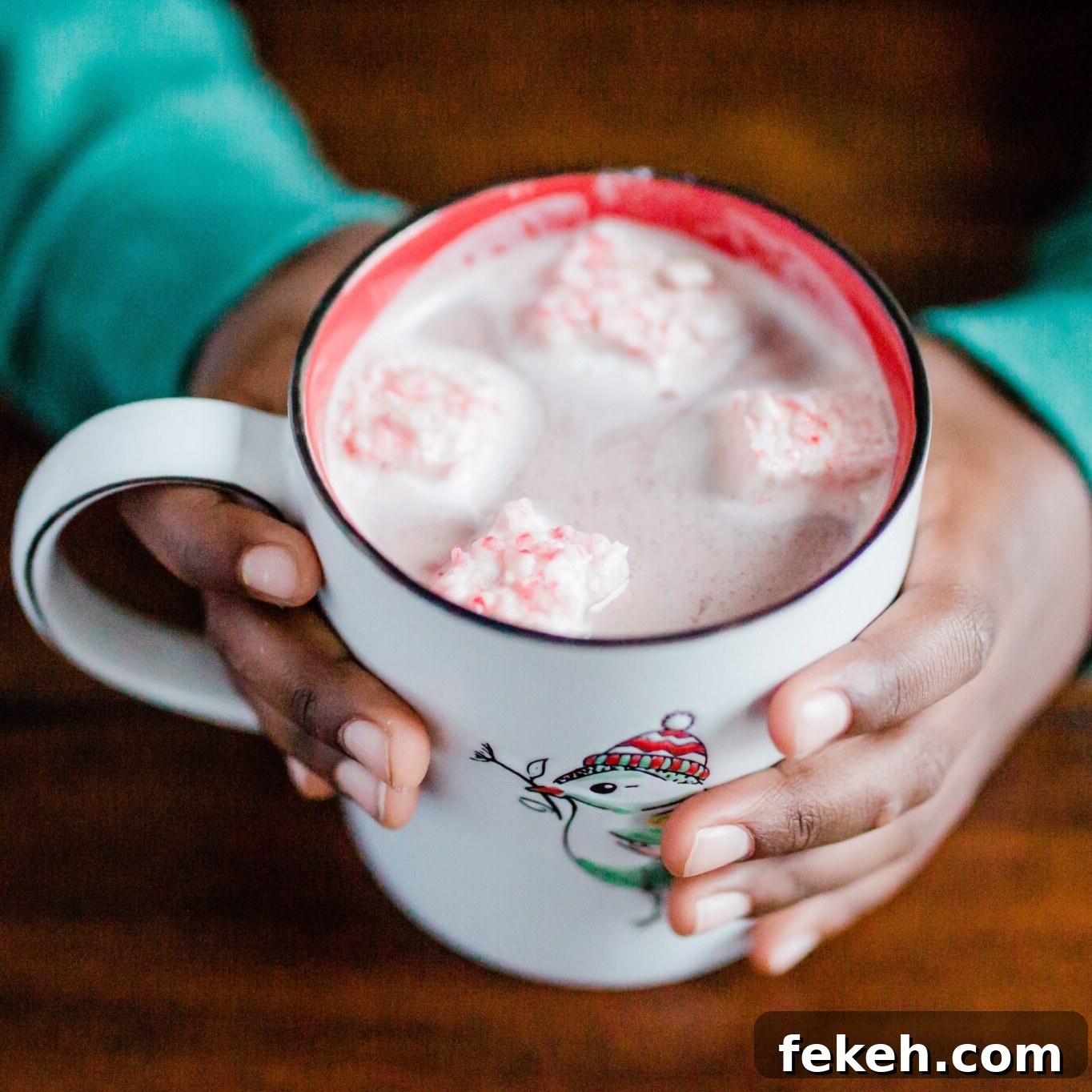 Square image of hands holding a mug of hot chocolate