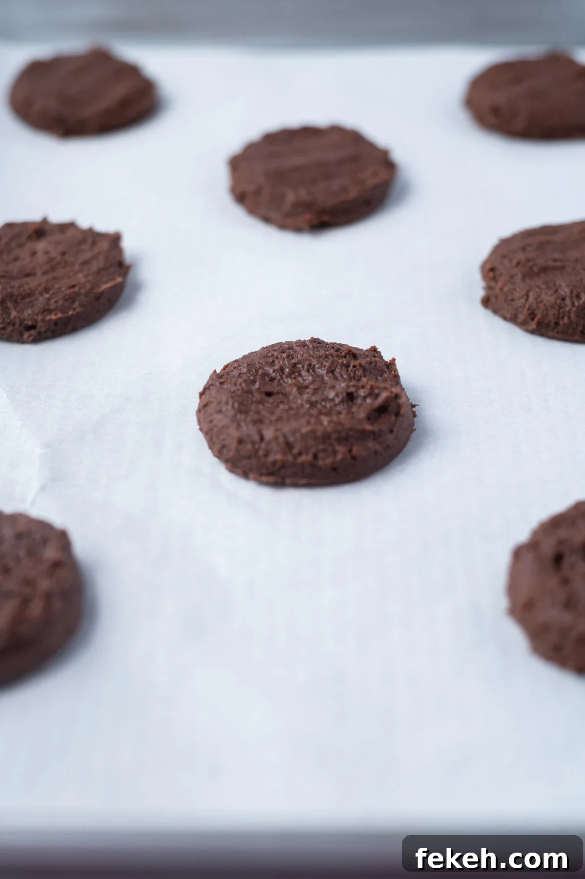 Fudgy Cosmic Brownie Cookie Recipe for Gooey Chocolate Lovers 9 cookie dough pressed down on a parchment lined baking sheet