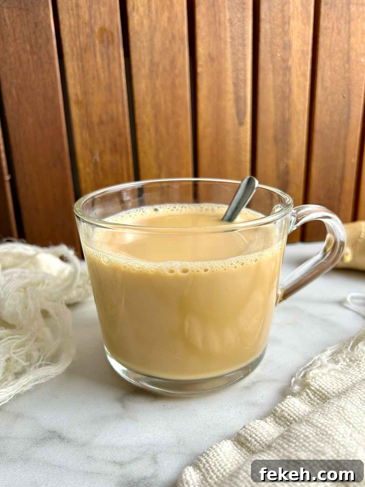 Chinese Ginger Milk Tea Recipe: Authentic Hot Drink with Fresh Ginger 2 side view of ginger milk tea in glass cup.