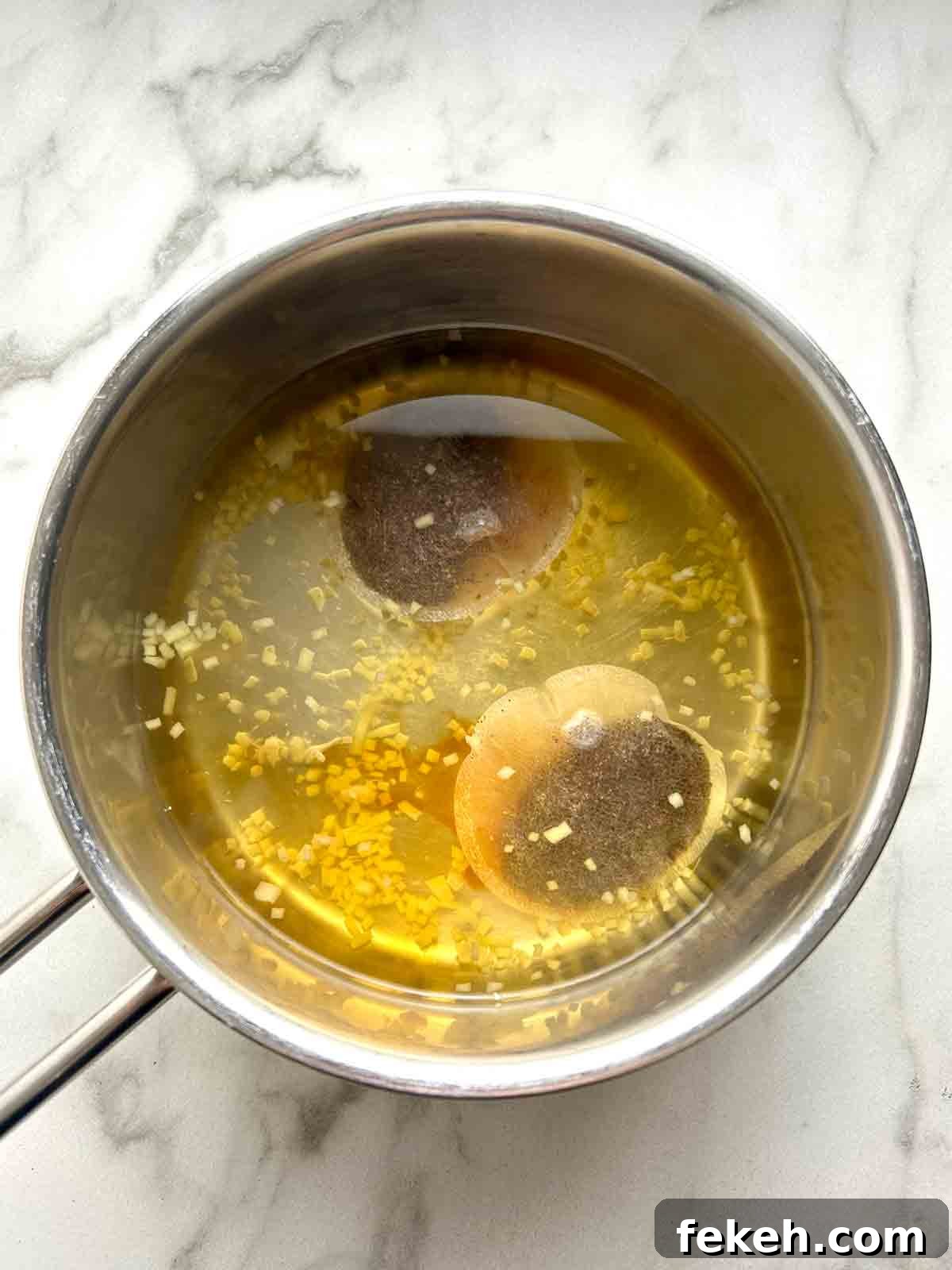 Chinese Ginger Milk Tea Recipe: Authentic Hot Drink with Fresh Ginger 4 tea bags and minced ginger adding to boiling water.