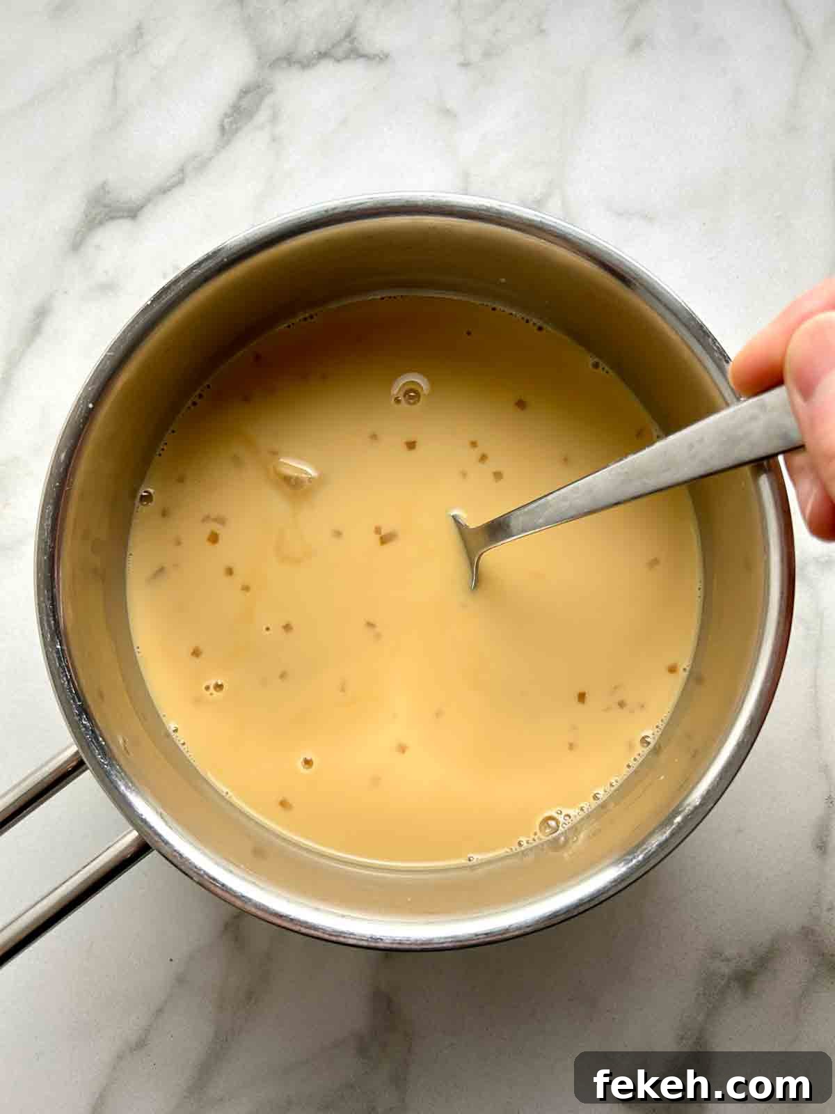 Chinese Ginger Milk Tea Recipe: Authentic Hot Drink with Fresh Ginger 6 evaporated milk and condensed milk being stirred into steeped tea.