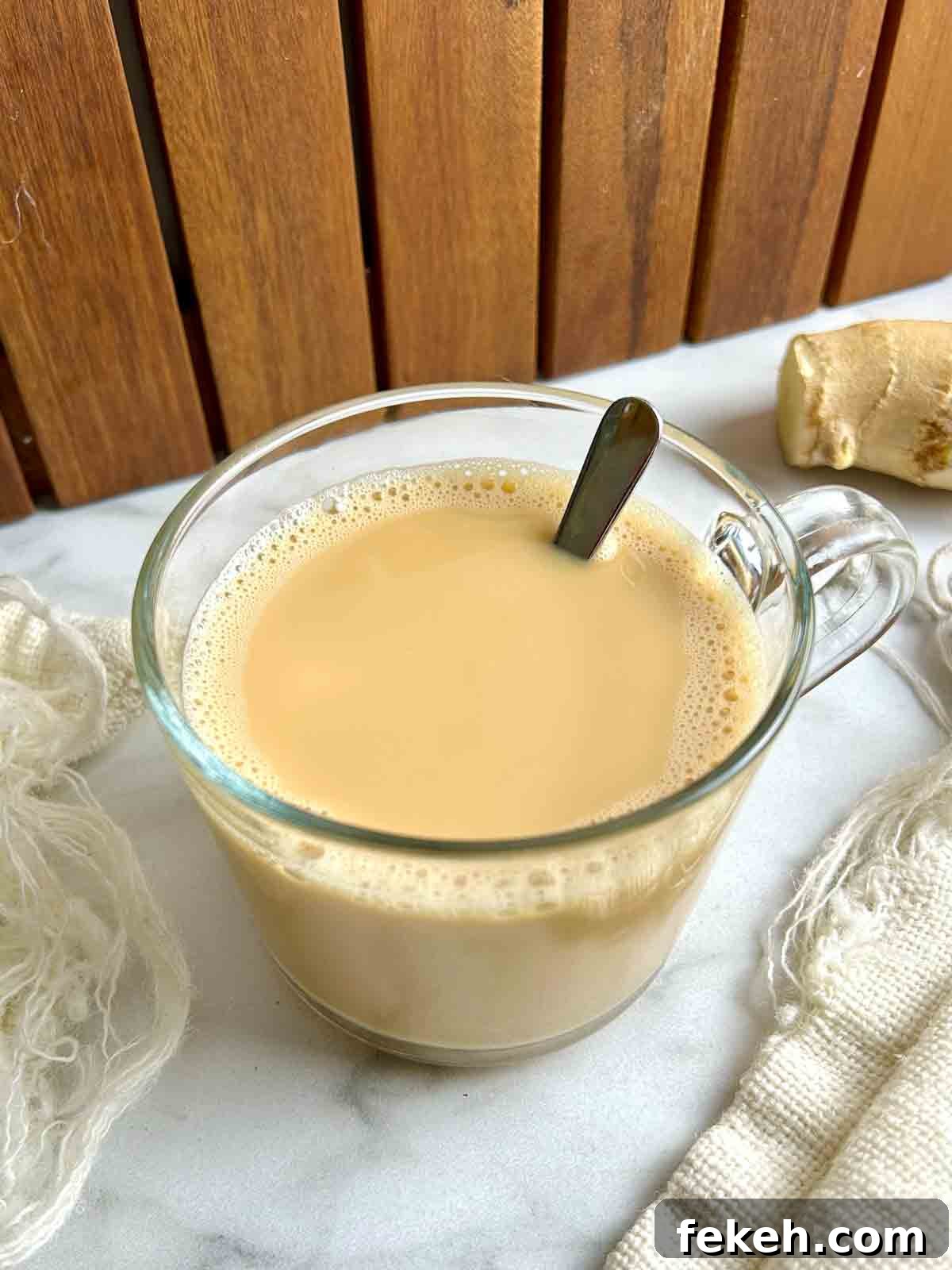 Chinese Ginger Milk Tea Recipe: Authentic Hot Drink with Fresh Ginger 8 angled view of ginger milk tea in glass cup.
