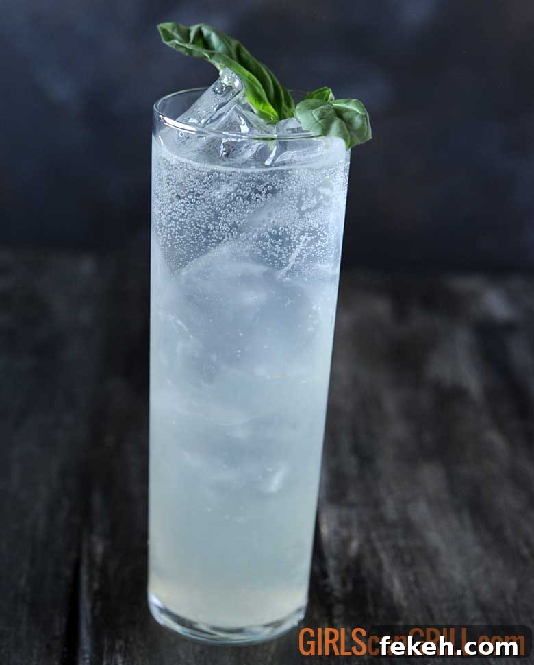 Smoked Tom Collins with Basil-Smoked Simple Syrup 3 tall narrow glass of smoked basil tom collins with basil sprig