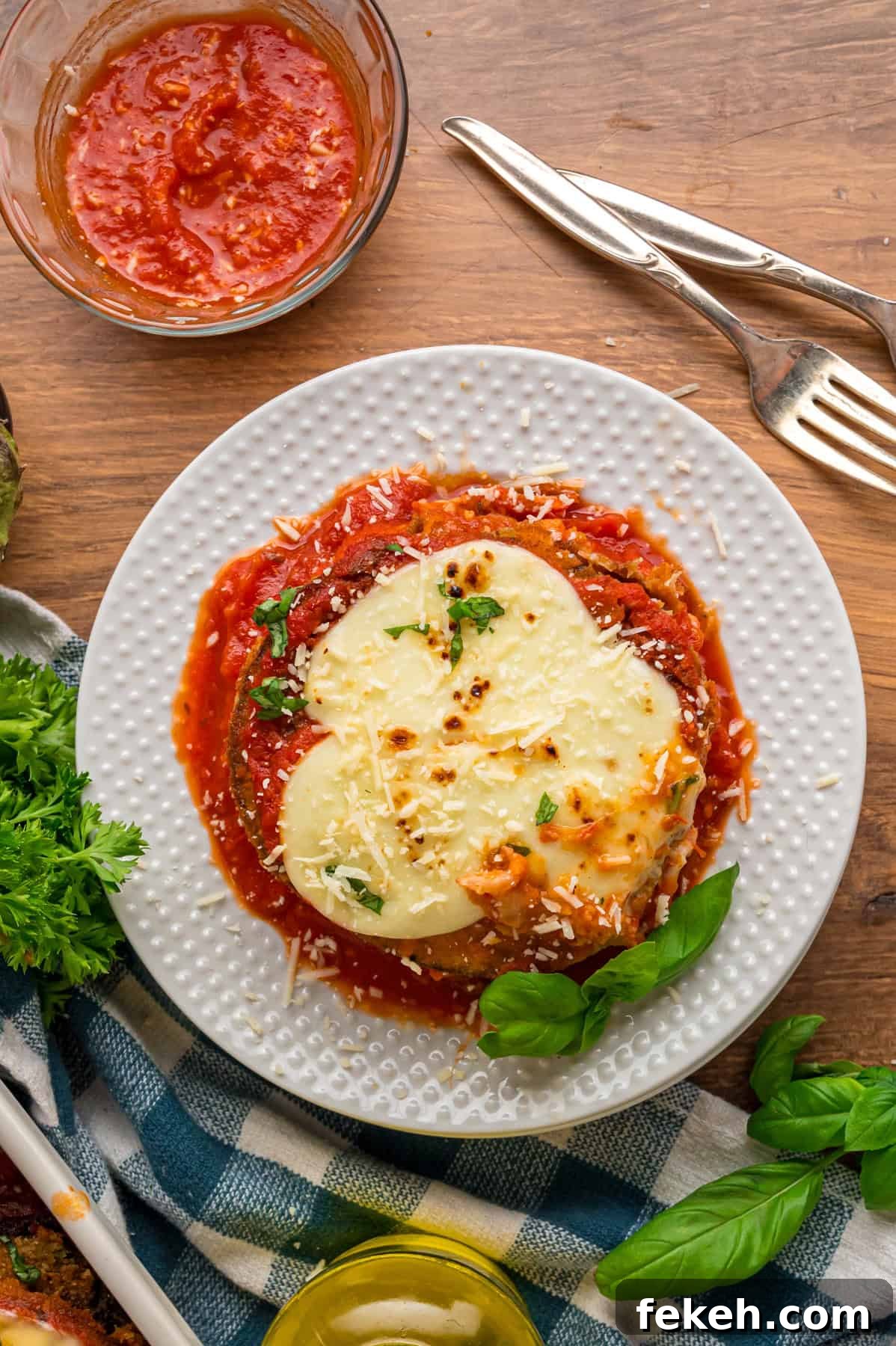 Layers of crispy fried eggplant, gooey cheese, and marinara sauce make this Eggplant Parmesan recipe an irresistibly easy weeknight dinner. A plate of eggplant parmesan