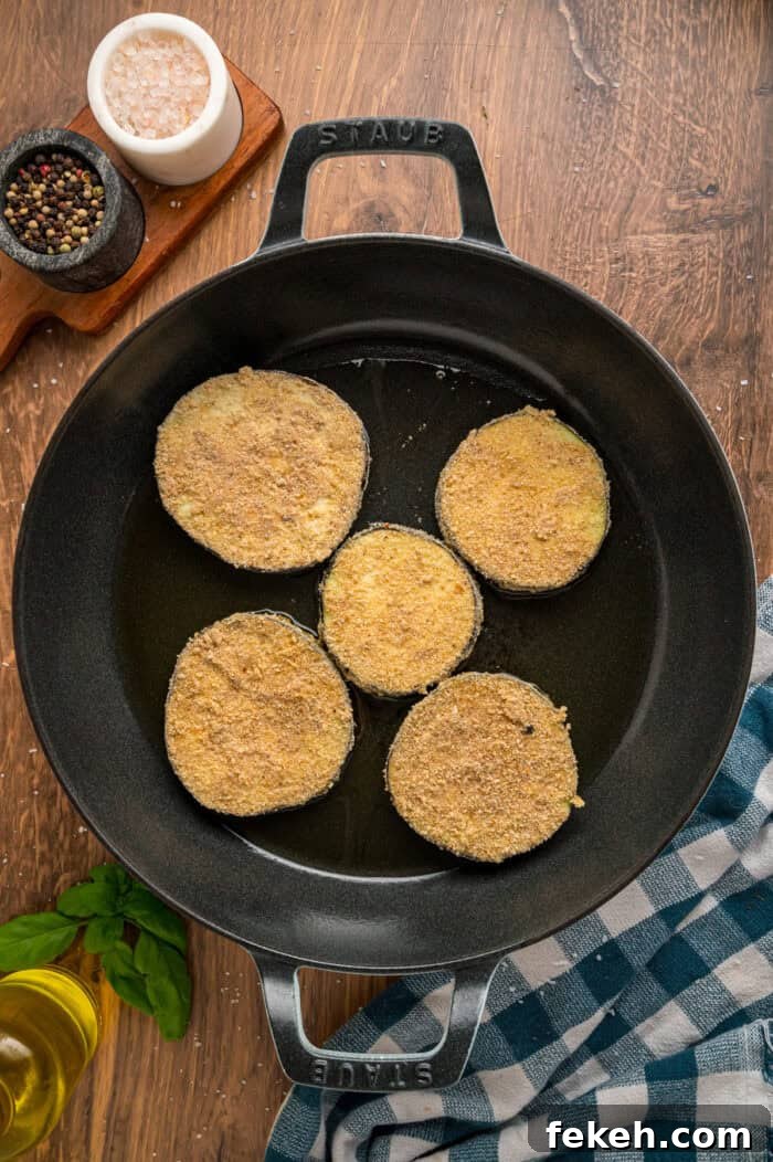 Breaded slices of eggplant frying in oil Breaded slices of eggplant frying in oil