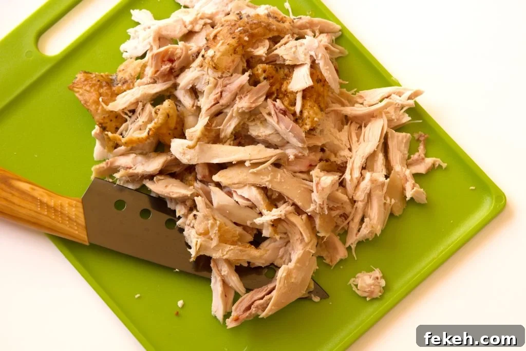 shredded rotisserie chicken on a cutting board