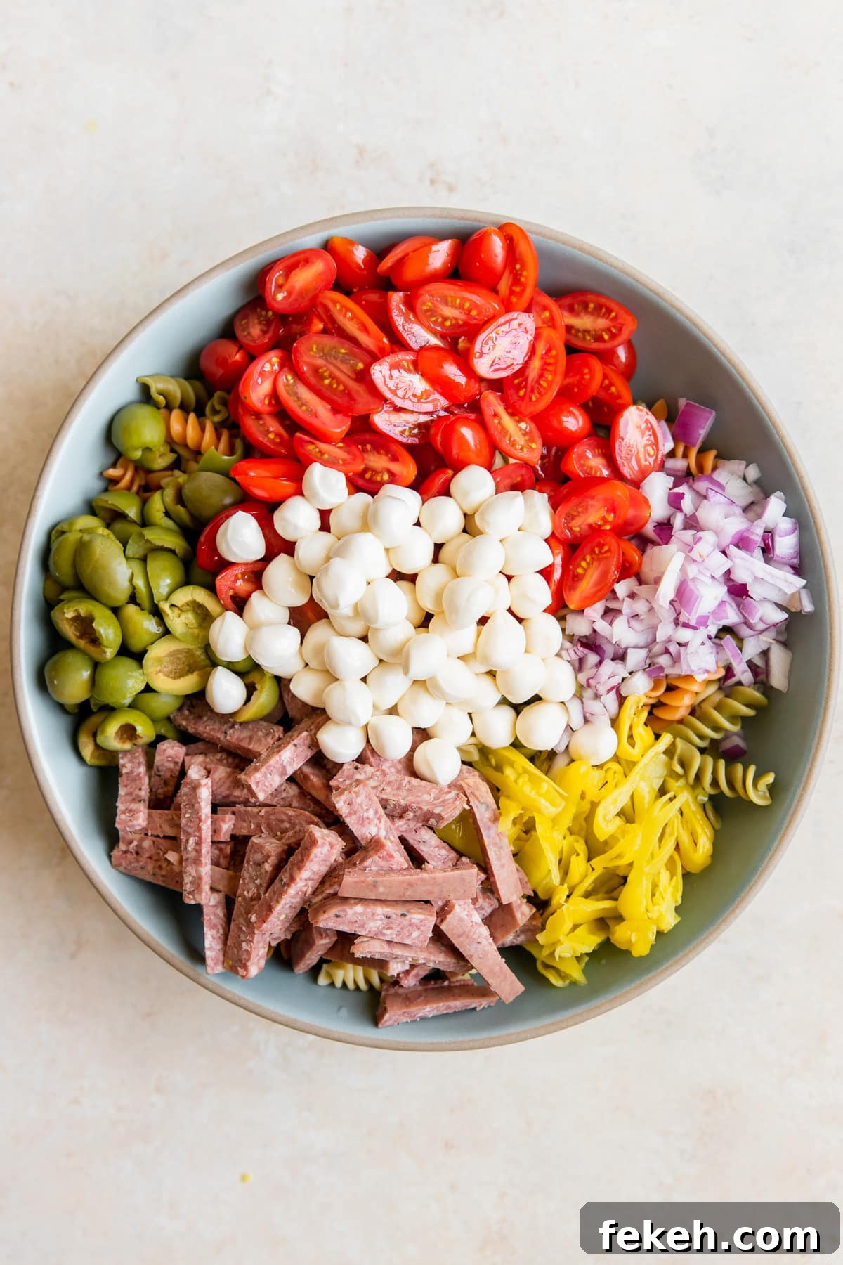 Quick Italian Pasta Salad Recipe for Summer Potlucks 2 pasta salad ingredients in a large blue bowl.