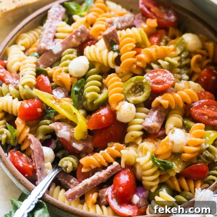 pasta in a bowl with sausage and tomatoes and cheese.